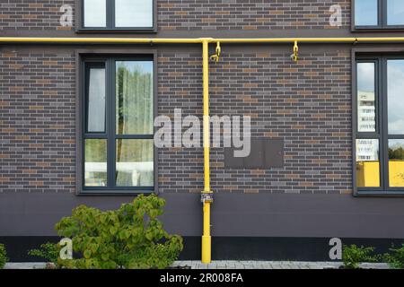 Gelbe Gasleitungen in der Nähe von Ziegelmauern im Freien Stockfoto