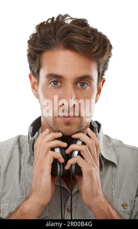 Er verirrt sich gleich in seinen Melodien. Porträt eines gutaussehenden jungen Mannes, der Kopfhörer um den Hals trägt. Stockfoto