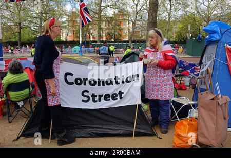 Während der Krönung des Königs in London haben sich einige Leute möglicherweise in der Mall aufgehalten und sich verkleidet, während sie ein Schild mit der Aufschrift „Coronation Street“ hielten, auf dem die beliebte britische Seifenoper steht. Stockfoto