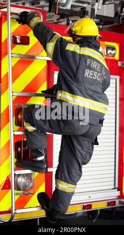 Feuerwehrmann, Mann und Kletterleiter für Notbetrieb, Wartung oder Rettung mit Ausrüstung. Feuerwehrmann mit Helm, Jacke und Schutzausrüstung Stockfoto