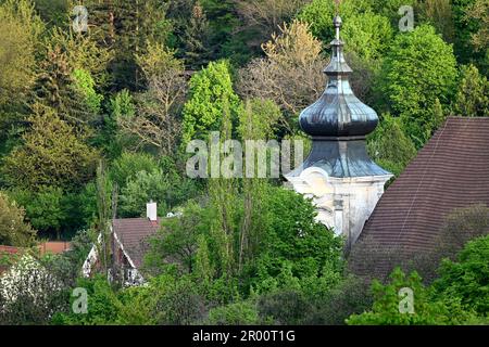 Malerische Dorfkirche St. Cosmas und Damian (Farský kostol sv. Kozmu a Damiána) in Dubravka bei Bratislava, mit Bäumen in einem grünen Waldgebiet Stockfoto