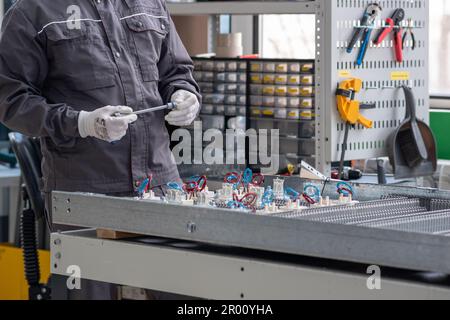 Perm, Russland - 25. April 2023: Mitarbeiter betreibt eine automatische Produktionslinie (PCB-Drucker) in einer Werkstatt Stockfoto