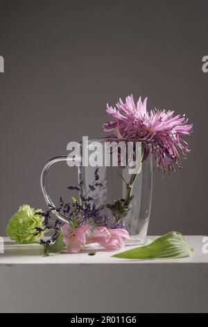 Verwelkte Blumen in einem Glasbecher Stockfoto