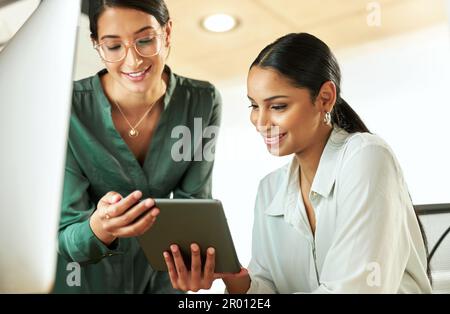 Ich bin so froh, dass du dein Tablet mitgebracht hast. Eine junge Geschäftsfrau, die ihr digitales Tablet an ihrem Schreibtisch verwendet. Stockfoto