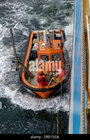 Ein kleines seismisches Arbeitsboot der Norpower, das nach Arbeitsbootoperationen auf den seismischen Luftschlangen vor Gabun auf dem seismischen Mutterschiff geborgen wird. Stockfoto