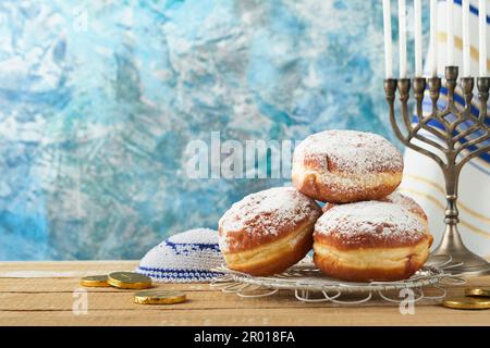 Frohes Chanukka. Chanukka altes Menorah vor dem Hintergrund der israelischen Flagge mit Sonnenlicht oder Bokeh auf weißem Holzhintergrund. Religionsbild der juden Stockfoto