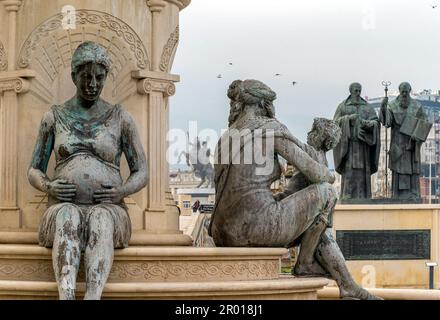 Skopje, Nordmazedonien. Die Mütter von Mazedonien Brunnenstatuen, mit der Statue der Heiligen Cyril und Methodius und Alexander dahinter Stockfoto