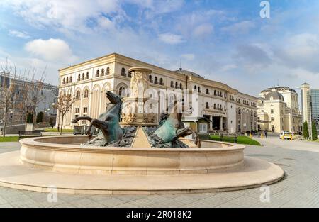 Skopje, Nordmazedonien, Blick auf den Pferdebrunnen und Museum des mazedonischen Kampfes auf dem Rebellion Square Stockfoto