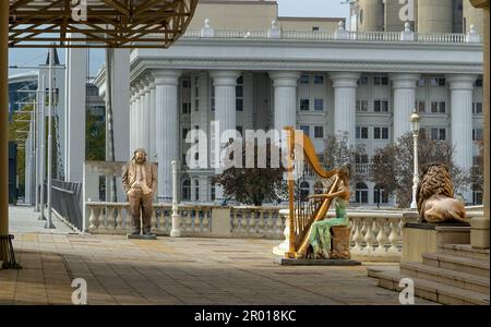 Mazedonisches Nationaltheater mit der Statue einer Harfenspielerin davor und der Statue eines Schauspielers im Hintergrund Stockfoto