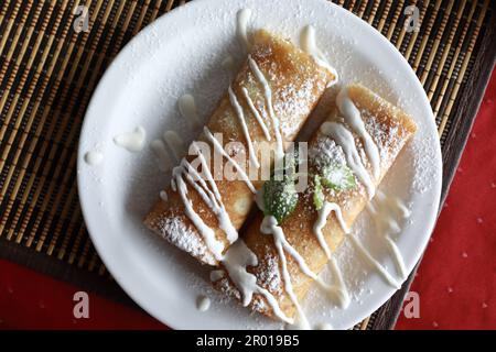 Pfannkuchen gefüllt mit Hüttenkäse auf dem Teller im Restaurant Stockfoto
