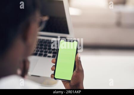Optimierung Ihrer Webseite für Mobiltelefone. Eine unbekannte Geschäftsfrau, die allein in ihrem Büro sitzt und ihr Handy benutzt. Stockfoto