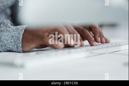 Die Beantwortung von E-Mails ist ein wesentlicher Bestandteil des Geschäfts. Ein unbekannter Geschäftsmann, der allein im Büro sitzt und auf der Tastatur tippt. Stockfoto