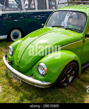 Nahaufnahme des vorderen Endes einschließlich Motorhaube, Scheinwerfer, Kühlergrill und Emblem eines klassischen und restaurierten VW-Käfers auf einem kleinen und lokalen Außenbereich Stockfoto