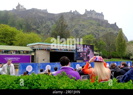 Edinburgh, Schottland, Großbritannien. 6. Mai 2023 Eine Live-Besichtigung der Krönung von König Karl III auf einer großen Leinwand am Ross Bandstand in West Princes Street Gardens vor der Kulisse von Edinburgh Castle. Kredit: Craig Brown/Alamy Live News Stockfoto