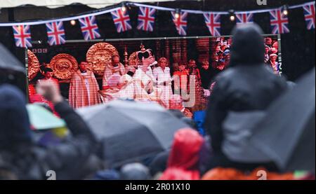 Brighton UK, 6. Mai 2023 - die Massen beobachten heute im Regen die Krönung von König Charles III auf einer großen Leinwand in Brightons Jubilee Square : Credit Simon Dack / Alamy Live News Stockfoto