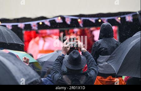 Brighton UK, 6. Mai 2023 - die Massen beobachten heute im Regen die Krönung von König Charles III auf einer großen Leinwand in Brightons Jubilee Square : Credit Simon Dack / Alamy Live News Stockfoto