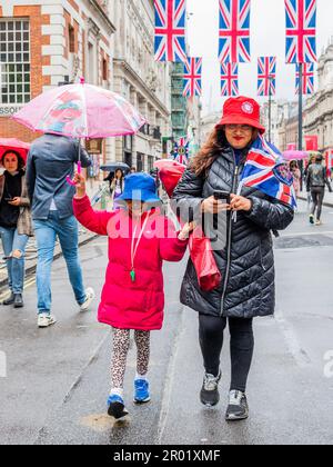 London, Großbritannien. 6. Mai 2023. Besucher versuchen, das Beste aus dem Regen zu machen - der Regen kam runter und Zehntausende Menschen waren enttäuscht und dazu verdammt, durch die Straßen zu schlendern, als die Organisatoren die Tore am Rande sehr früh am Morgen geschlossen haben. Die Krönung von König Karl III. Am 6. Mai. Kredit: Guy Bell/Alamy Live News Stockfoto