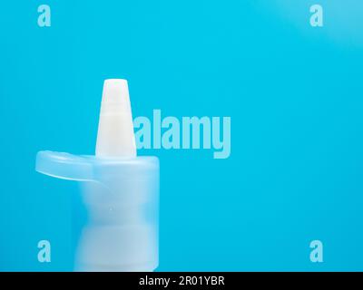 Nasenspray-Flaschen auf blauem Hintergrund, Behandlung einer Erkältung mit Nasenspray. Medizin-Nahaufnahme. Stockfoto