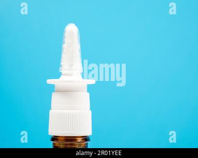 Nasenspray-Flaschen auf blauem Hintergrund, Behandlung einer Erkältung mit Nasenspray. Medizin-Nahaufnahme. Stockfoto