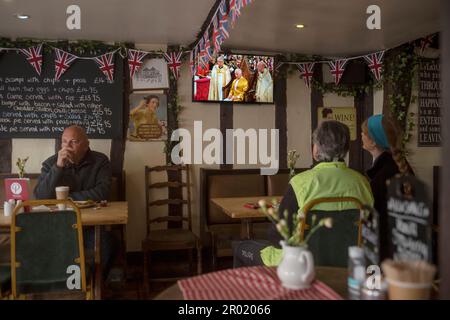 Thaxted, England, Gb 06. Mai 2023. Coronation King Charles III Thaxted Essex UK 6 Mai 2023 die Krönung von König Charles III und Königin Camilla in Westminster Abbey in London, wie im Fernsehen in der Parrishes Wine Bar in Thaxted in North Essex, England, zu sehen ist. Foto von Credit: BRIAN HARRIS/Alamy Live News Stockfoto