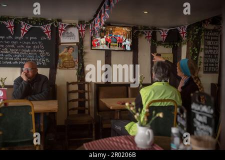 Thaxted, England, Gb 06. Mai 2023. Coronation King Charles III Thaxted Essex UK 6 Mai 2023 die Krönung von König Charles III und Königin Camilla in Westminster Abbey in London, wie im Fernsehen in der Parrishes Wine Bar in Thaxted in North Essex, England, zu sehen ist. Foto von Credit: BRIAN HARRIS/Alamy Live News Stockfoto