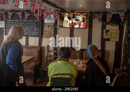 Thaxted, England, Gb 06. Mai 2023. Coronation King Charles III Thaxted Essex UK 6 Mai 2023 die Krönung von König Charles III und Königin Camilla in Westminster Abbey in London, wie im Fernsehen in der Parrishes Wine Bar in Thaxted in North Essex, England, zu sehen ist. Foto von Credit: BRIAN HARRIS/Alamy Live News Stockfoto