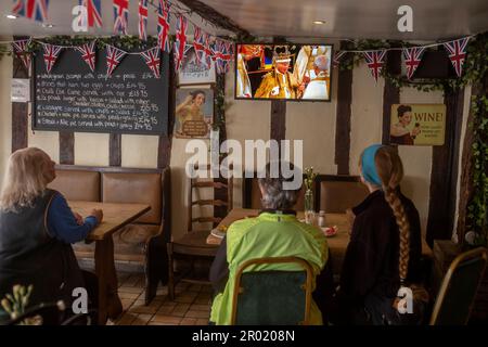 Thaxted, England, Gb 06. Mai 2023. Coronation King Charles III Thaxted Essex UK 6 Mai 2023 die Krönung von König Charles III und Königin Camilla in Westminster Abbey in London, wie im Fernsehen in der Parrishes Wine Bar in Thaxted in North Essex, England, zu sehen ist. Foto von Credit: BRIAN HARRIS/Alamy Live News Stockfoto