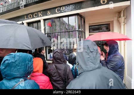 6. Mai 2023. Die Leute versuchen, die Krönung in den Schaufenstern des Rain zu sehen. Credit: Londonphotos/Alamy Live News Stockfoto