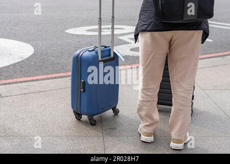 Unbekannte Touristin mit Rollkoffer in der Stadt Stockfoto