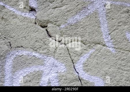 Großer Gabelriss an der alten lackierten Putzwand. Speicherplatz kopieren. Selektiver Fokus. Stockfoto