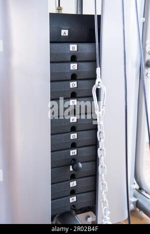 Fitnessgerät für Krafttraining. Gewicht auf der Hubmaschine Stockfoto