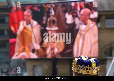 King's Coronation Celebrations auf der großen Leinwand am Times Square, beobachtet von der Öffentlichkeit mit Hüten, Flaggen und Kronen, Newcastle upon Tyne, Großbritannien, 6. Mai, 2023, Kredit: DEW/Alamy Live News Stockfoto