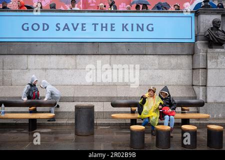 Mitglieder der Öffentlichkeit ruhen sich aus, nachdem sie die Krönungsrunde von König Karl III. Am Trafalgar Square am 6. Mai 2023 in London, England, gesehen haben. Stockfoto