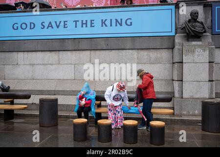 Mitglieder der Öffentlichkeit ruhen sich aus, nachdem sie die Krönungsrunde von König Karl III. Am Trafalgar Square am 6. Mai 2023 in London, England, gesehen haben. Stockfoto