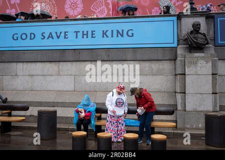 Mitglieder der Öffentlichkeit ruhen sich aus, nachdem sie die Krönungsrunde von König Karl III. Am Trafalgar Square am 6. Mai 2023 in London, England, gesehen haben. Stockfoto