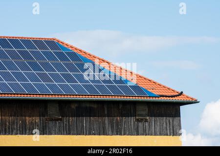 Sonnenkollektoren auf dem Dach einer Scheune Stockfoto