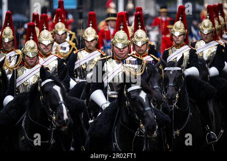 London, Großbritannien. 06. Mai 2023. Soldaten auf dem Pferderücken begleiten die Kutsche des gekrönten Königspaares von Westminster Abbey zurück zum Buckingham Palace. Kredit: Sina Schuldt/dpa/Alamy Live News Stockfoto