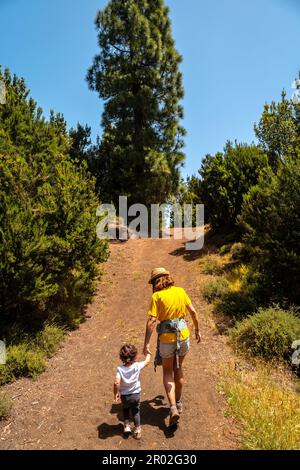 Eine Mutter mit ihrem Sohn, die einen Hügel auf dem La Llania Trekking Trail in El Hierro, Kanarische Inseln, hinaufgeht Stockfoto