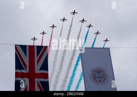 Strand, Westminster, London, Großbritannien. 6. Mai 2023. Auf die Krönungszeremonie und die Prozession zurück zum Buckingham-Palast folgte aufgrund des schlechten Wetters eine abgeschnittene Flypast. Hinter Hubschraubern der Royal Air Force, Royal Navy & Army Air Corps folgten die RAF Red Arrows, die hier über Krönung und Union Jack-Flaggen flogen Stockfoto