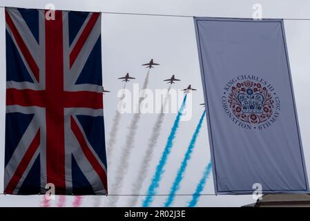 Strand, Westminster, London, Großbritannien. 6. Mai 2023. Auf die Krönungszeremonie und die Prozession zurück zum Buckingham-Palast folgte aufgrund des schlechten Wetters eine abgeschnittene Flypast. Hinter Hubschraubern der Royal Air Force, Royal Navy & Army Air Corps folgten die RAF Red Arrows, die hier über Krönung und Union Jack-Flaggen flogen Stockfoto