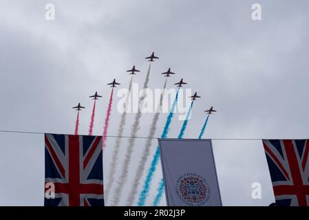 Strand, Westminster, London, Großbritannien. 6. Mai 2023. Auf die Krönungszeremonie und die Prozession zurück zum Buckingham-Palast folgte aufgrund des schlechten Wetters eine abgeschnittene Flypast. Hinter Hubschraubern der Royal Air Force, Royal Navy & Army Air Corps folgten die RAF Red Arrows, die hier über Krönung und Union Jack-Flaggen flogen Stockfoto