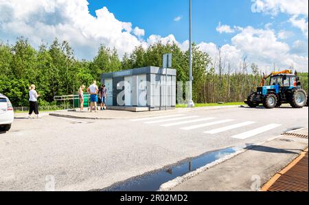 Moskau Region, Russland - 12. Juli 2022: Menschen stehen in der Schlange nahe der öffentlichen Toilette auf dem Parkplatz der Autobahn M11 am Sommertag Stockfoto