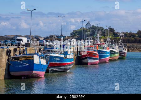 Farbenfrohe Fischerboote im Hafen von Roscoff mit Chapelle Sainte Barbe im Hintergrund, Bretagne, Frankreich Stockfoto