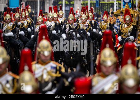 London, Großbritannien. 06. Mai 2023. Soldaten auf dem Pferderücken begleiten die Kutsche des gekrönten Königspaares von Westminster Abbey zurück zum Buckingham Palace. Kredit: Sina Schuldt/dpa/Alamy Live News Stockfoto