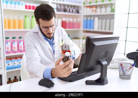 Junger hispanischer Apotheker-Scanning-Medikamentenflasche in der Apotheke Stockfoto