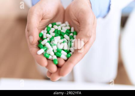 Junger hispanischer Apotheker mit Pillen in der Apotheke Stockfoto