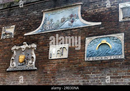 Alte Giebel an einer Wand, die Handwerke und Berufe von Hausbewohnern in Amsterdam, Holland, Niederlande zeigen. Stockfoto