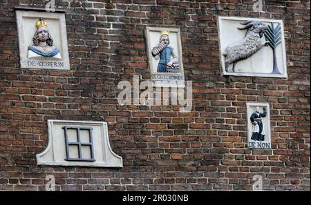 Alte Giebel an einer Wand, die Handwerke und Berufe von Hausbewohnern in Amsterdam, Holland, Niederlande zeigen. Stockfoto