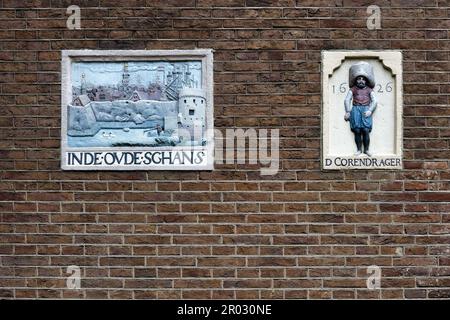 Alte Giebel an einer Wand, die Handwerke und Berufe von Hausbewohnern in Amsterdam, Holland, Niederlande zeigen. Stockfoto