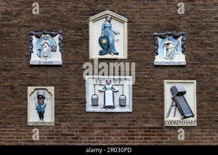 Alte Giebel an einer Wand, die Handwerke und Berufe in Amsterdam, Holland, Niederlande zeigt. Stockfoto